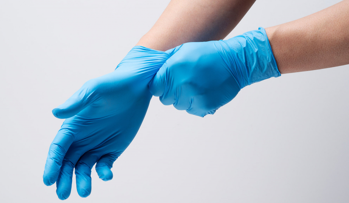 2 Hände mit Pflegehandschuhe