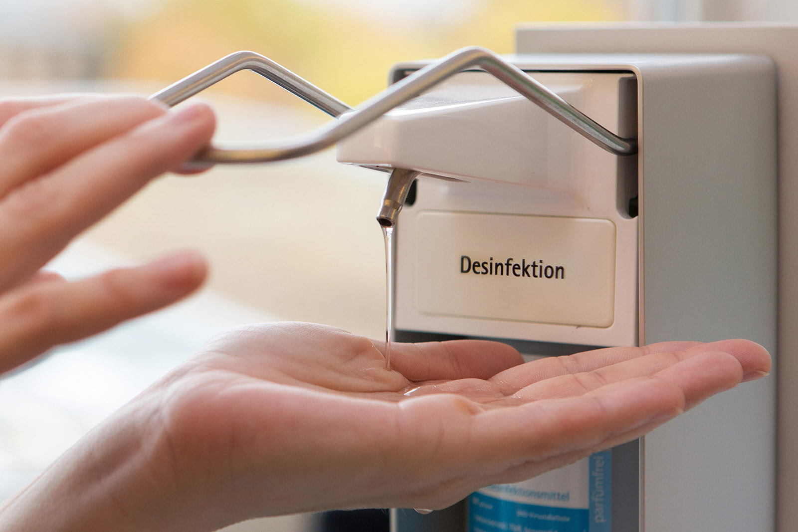 Hand unter Spender Desinfektionsmittel